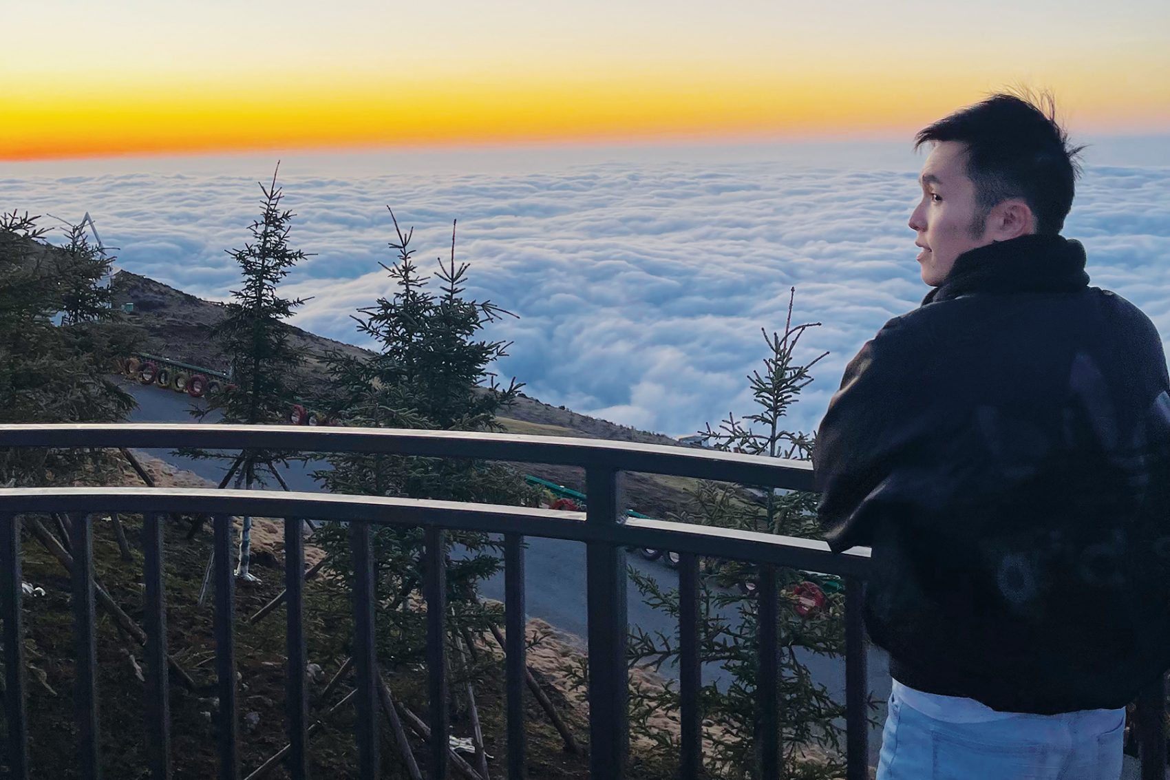 Flight Purser Mike Chin watches the sun set over a sea of clouds from a viewing platform on Niubei Mountain.